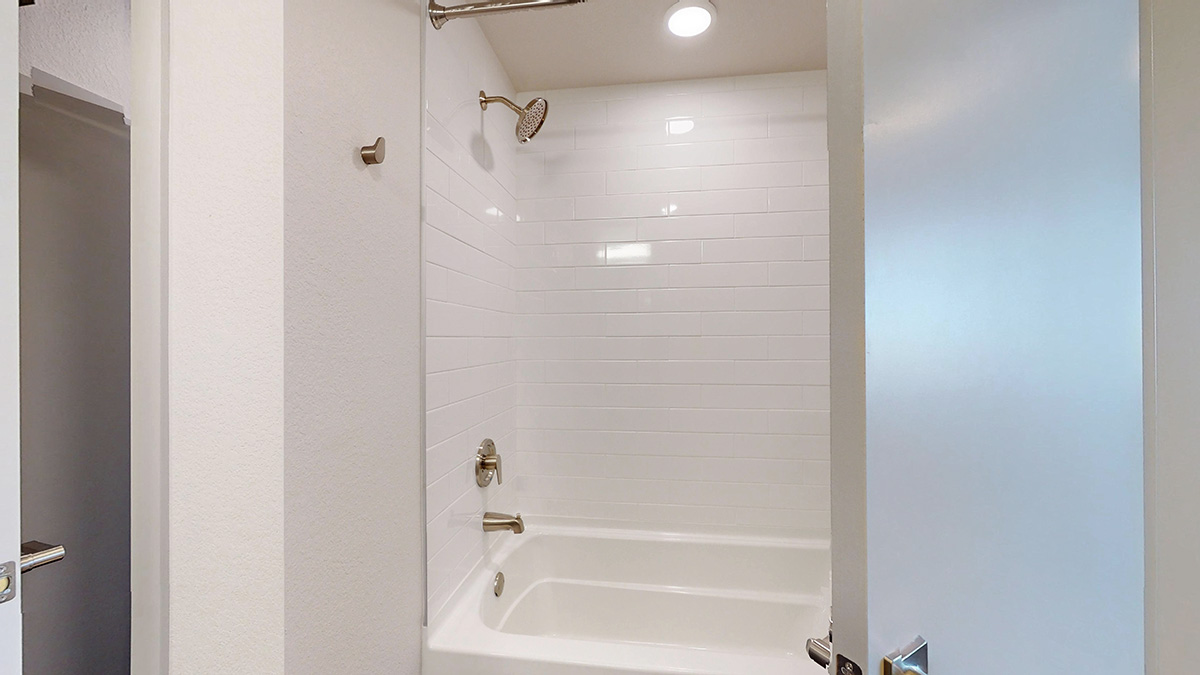 Bathroom with tiled surround tub shower combination
