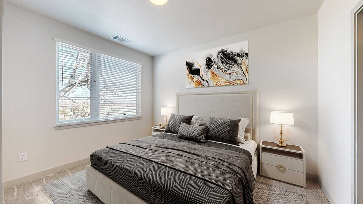 Model bedroom with large window and plush carpeting